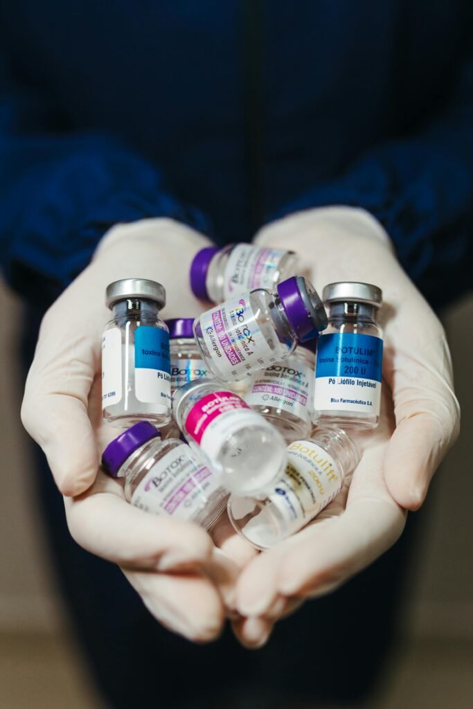 Close-up of gloved hands holding assorted medical vials, representing healthcare and medical supplies.